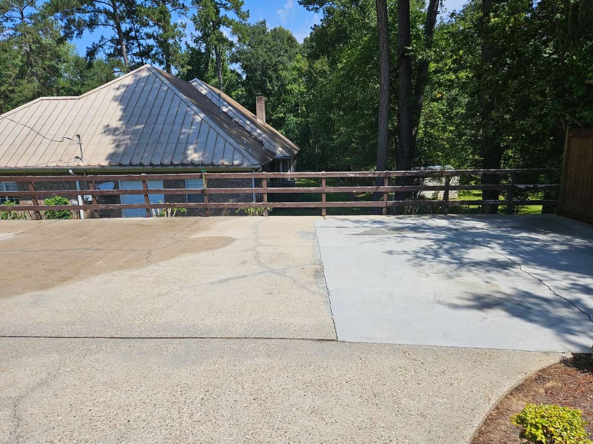 Cleaned concrete driveway beside a wooden railing in Collins